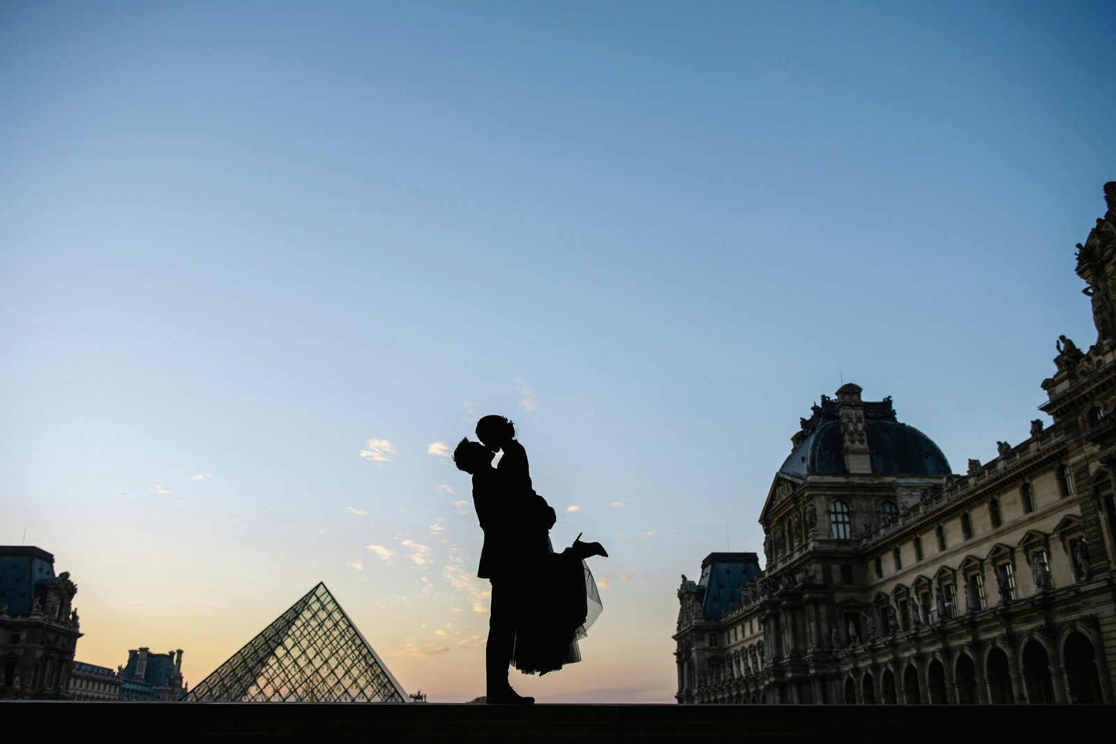 a person standing on a ledge in front of a building